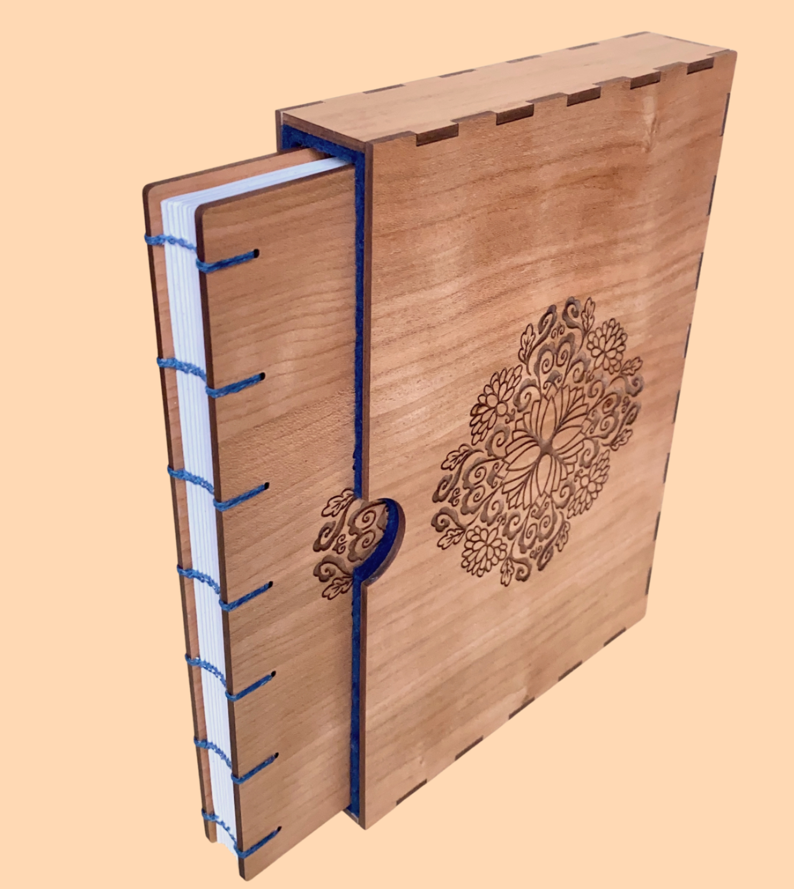 A book with walnut wood covers stands partly open against a pale orange background. There is a unique concentric circular pattern engraved on the front. The spine of the book is exposed and you can see each signature. Rusty red 4ply waxed Irish linen thread has been used to bind the pages using the coptic binding technique.