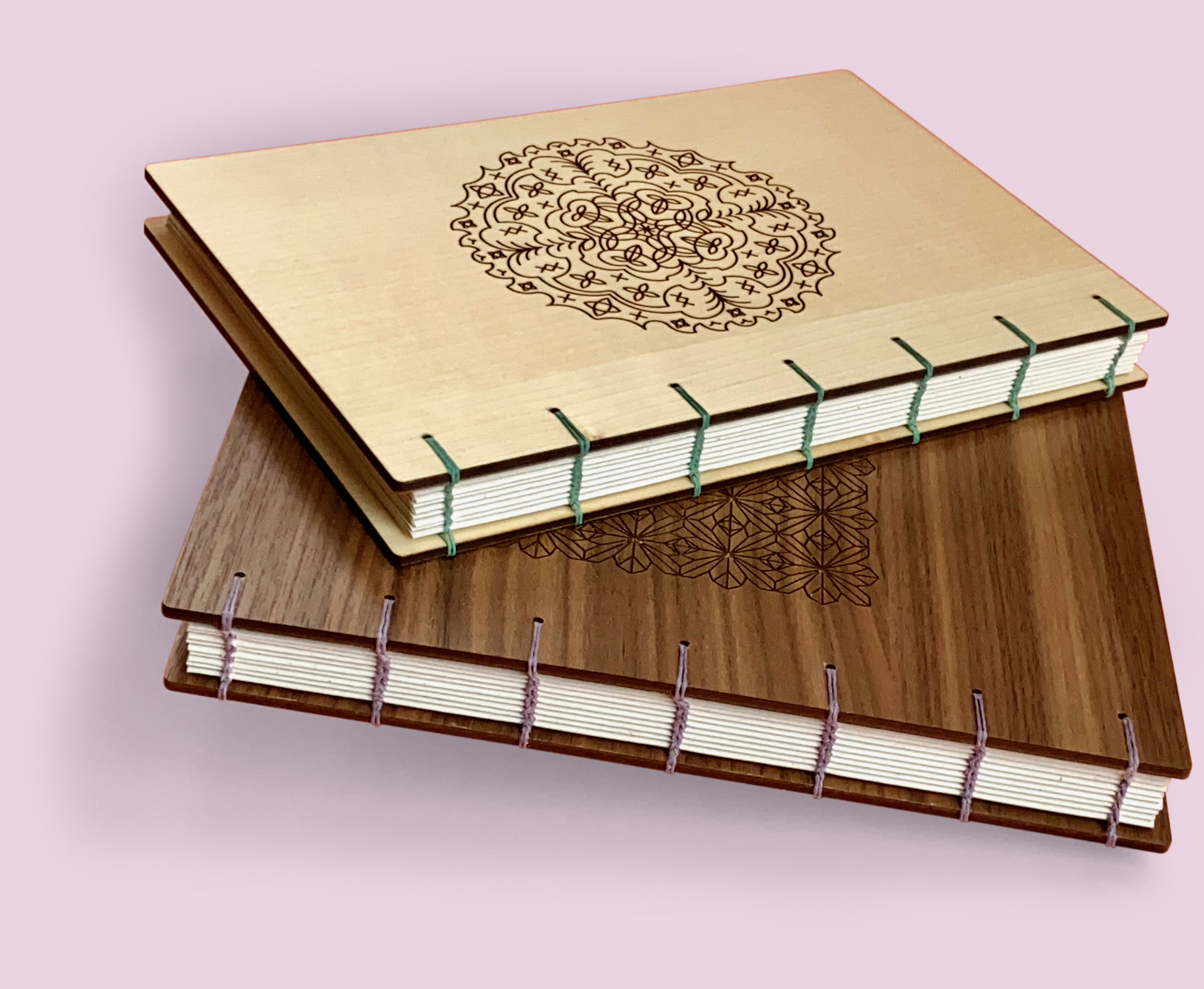 A book with walnut wood covers stands partly open against a pale yellow background. There is a unique concentric circlular pattern engraved on the front. The spine of the book is exposed and you can see each signature. Rusty red 4ply waxed Irish linen thread has been used to bind the pages using the coptic binding technique.